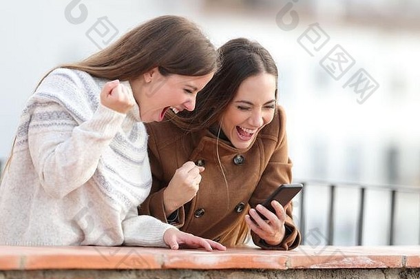 冬天，兴奋的女人们在一个乡村小镇的阳台上查看手机新闻