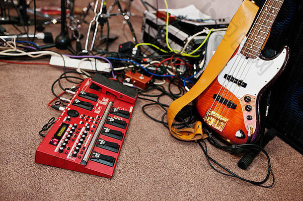 电低音吉他和吉他音频效果在录音室地板上。