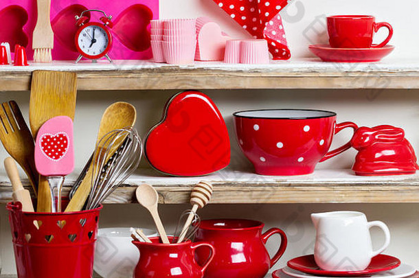 质朴的风格。架子上有红色的陶瓷餐具和厨房用具。
