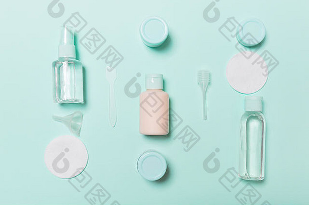 面部护理方法俯视图：蓝色背景上的补品、胶束清洁水、面霜、棉垫的瓶子和罐子。使用emp的身体护理概念