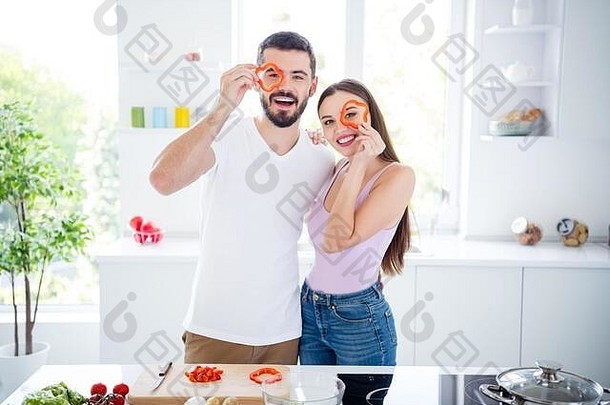 两人正面肖像素食者配偶拿着胡椒手表享受准备美味的菜肴午餐男人女人拥抱在厨房屋内
