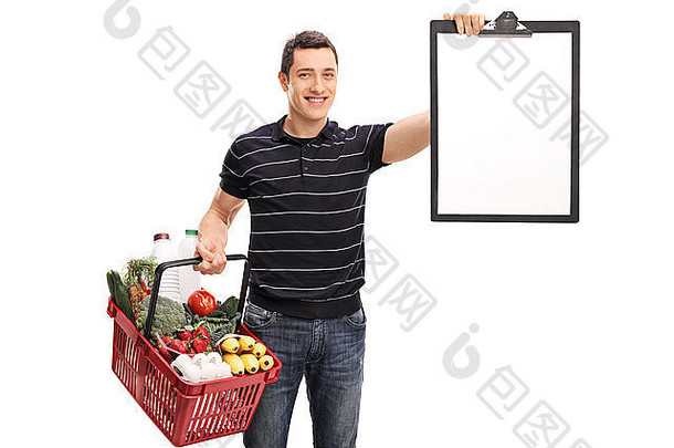 年轻的男人。持有购物篮子完整的食品杂货剪贴板孤立的白色背景