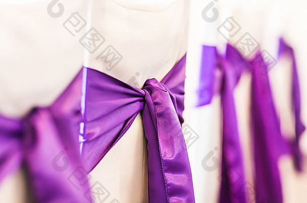 装饰着紫结的白色婚礼椅
