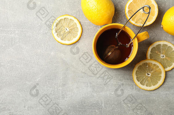 灰色背景上的一杯茶和柠檬，文本空间