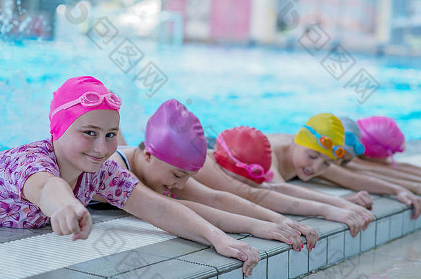 游泳池里快乐的孩子们。年轻成功的游泳运动员摆姿势。