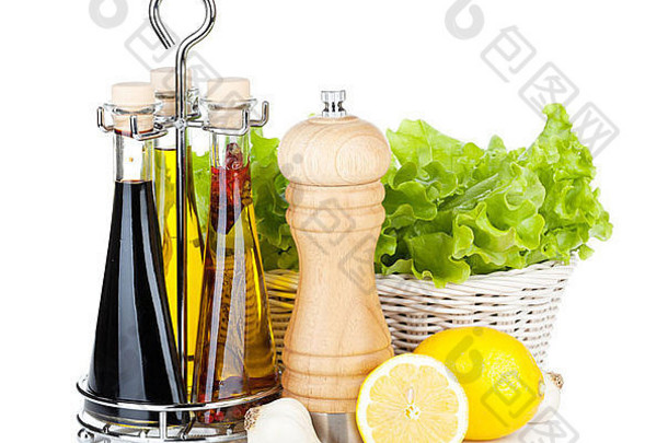 篮子里的生菜，配柠檬水果、胡椒粉、橄榄油和醋。在白色背景上隔离