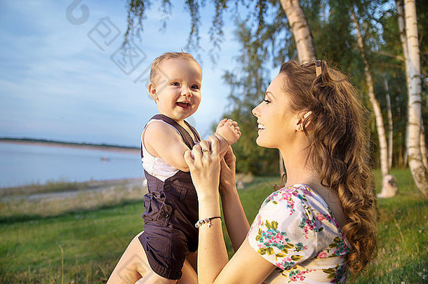 年轻的妈妈使婴儿笑