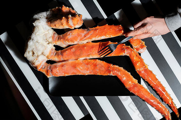 以<strong>大闸蟹</strong>腿为背景，手握叉子，俯视，海鲜美食