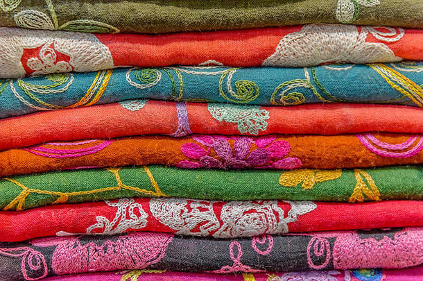 传统的色彩斑斓的丝绸羊绒头围巾披肩面料组成堆栈背景集市摊位伊斯坦布尔火鸡