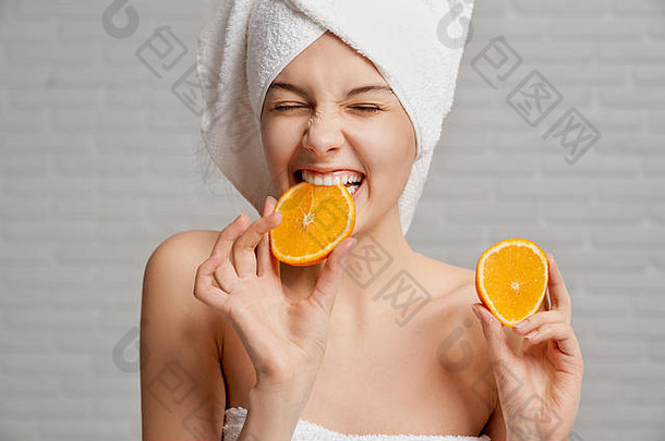 年轻的美丽的女孩完美的培养皮肤脸身体持有块橙色咬有吸引力的女人只肩膀白色毛巾