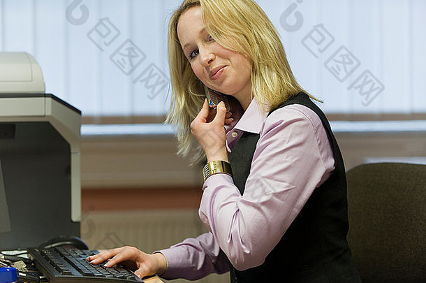 年轻的金发女郎秘书工作电脑会谈电话