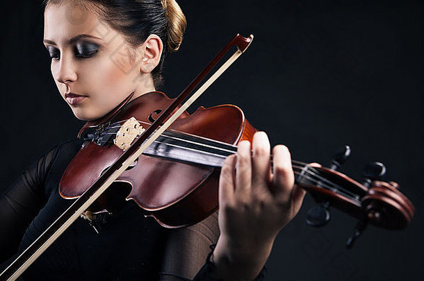 美丽的年轻的女人玩小提琴黑色的