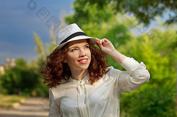 公园里一个戴着帽子的年轻漂亮女孩的肖像