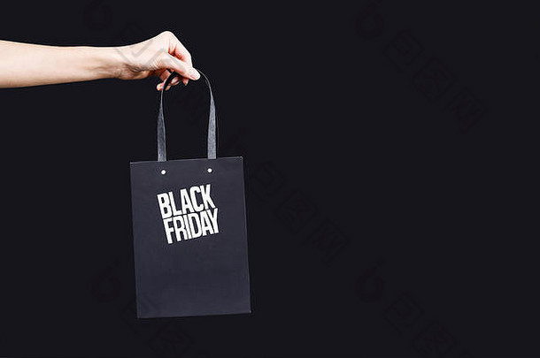作物视图女人手持有黑色的星期五纸购物袋处理黑色的背景黑色的星期五概念