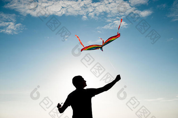 夏季蓝天下成年活动男子手持五彩风筝的自由观