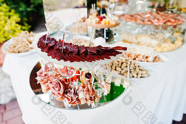 优雅的婚宴桌，配有食物和装饰。巴斯图玛火腿