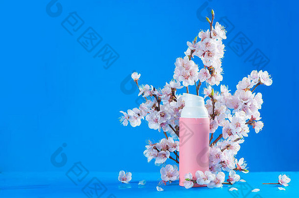 樱花<strong>化妆品</strong>。在天蓝色的背景上，带有<strong>春</strong>天花朵的<strong>粉色</strong>奶油管，带有空间。