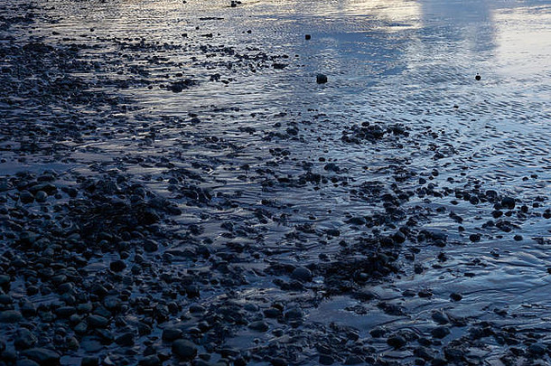 冰岛西部Borgarfjörður泥滩的抽象形状，在冬季昏暗的光线下呈现出深沉的颜色