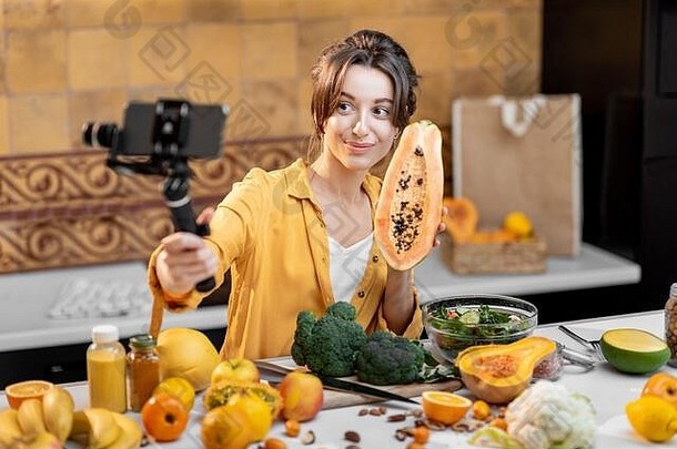 年轻开朗的女人在手机上谈论健康的食物和烹饪。健康饮食的概念与社交媒体的影响