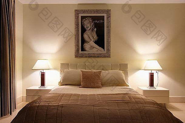 框架图片玛丽莲梦露床上米色被子现代卧室点燃灯表一边床上