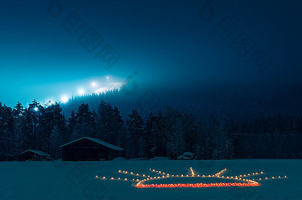 夜间雪景上的烛光装饰