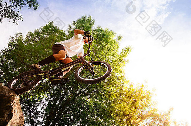 年轻的骑自行车的人边缘岩石跳试验自行车低角视图