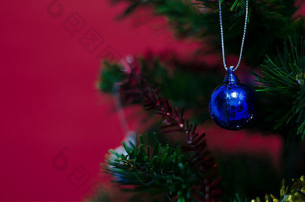 红色背景树上的蓝色圣诞球特写镜头