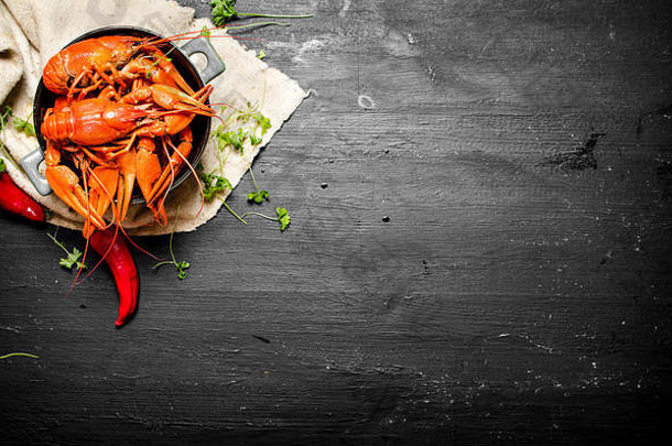 食物美味佳肴煮熟的小龙虾草本植物辣的辣椒黑色的黑板