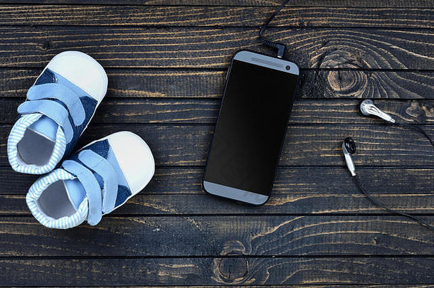 木地板上带耳机的童鞋和手机