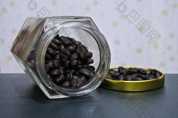 咖啡豆从带盖子的罐子里倒出。