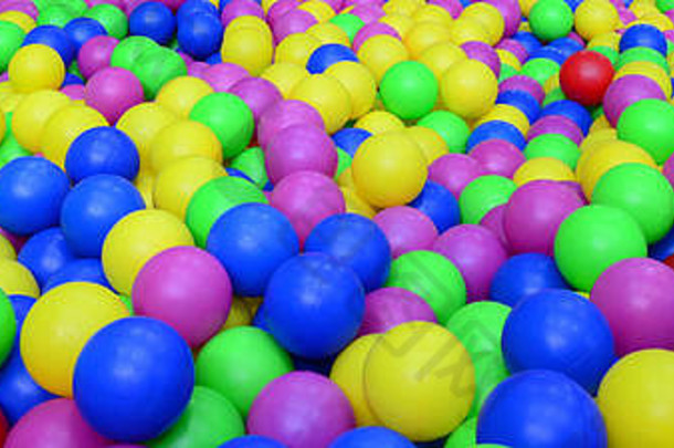 操场上的儿童棒球场里有许多五颜六色的塑料球。特写模式。