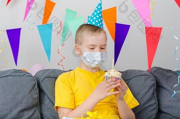 戴着节日纸杯蛋糕的药物<strong>面膜</strong>的快乐男孩庆祝生日。冠状病毒与检疫。独立的节日<strong>活动</strong>。社会距离。