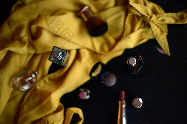 香水<strong>瓶口</strong>红化妆项目黄色的丝绸上衣黑色的背景