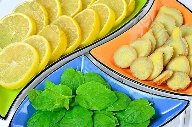 五颜六色的碗里放着柠檬、姜和薄荷叶。