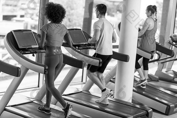 年轻人在现代健身房的跑步机上进行有氧运动