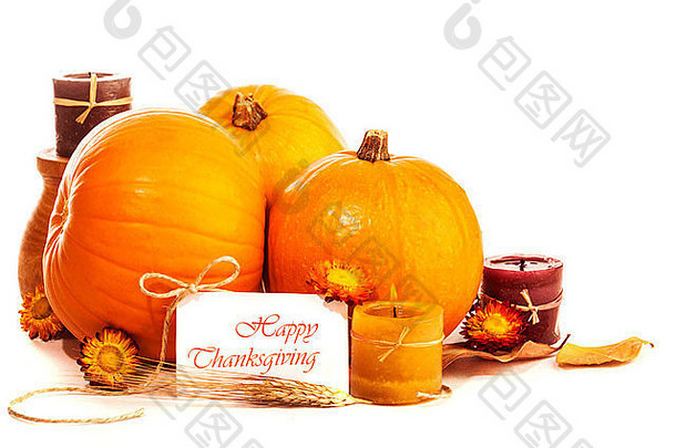 感恩节白色背景上的静物画，节日快乐，成熟的橘子瓜，蜡烛和干花