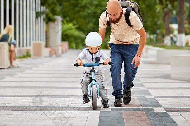 第一课骑自行车。父亲教儿子骑自行车。
