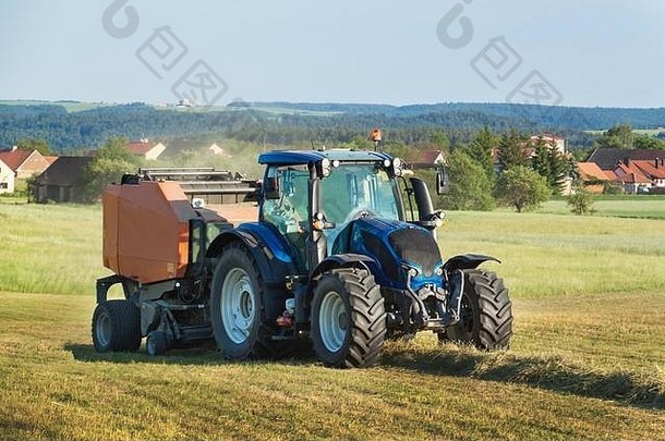 牧场上的蓝色拖拉机。。捷克共和国农场的农业工作