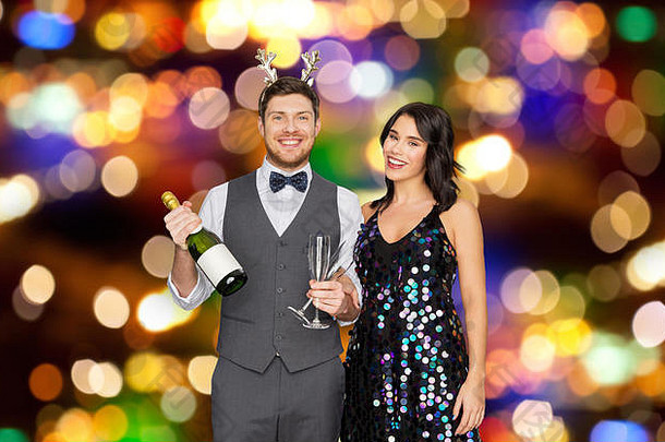 在圣诞派对上带着香槟酒瓶的情侣