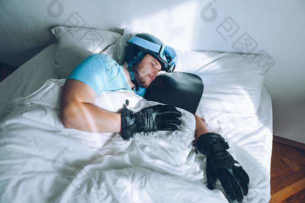 躺在床上的男人，戴着滑雪板滑雪镜和头盔