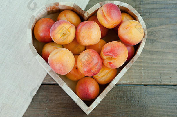桃子成熟的新鲜的健康的水果心形状的碗木背景