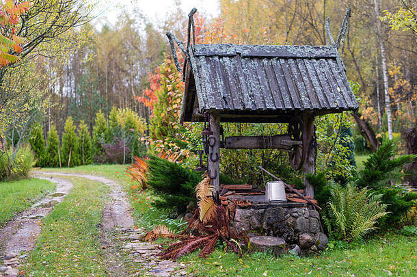 历史悠久的水井，带有木制屋顶农舍庭院。