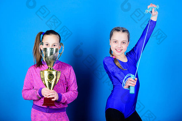 快乐儿童与金牌冠军杯。少女的胜利。比赛中的获胜者。杂技和体操。小女孩们拿着跳绳。体育成功。他们是新的冠军。我是冠军。
