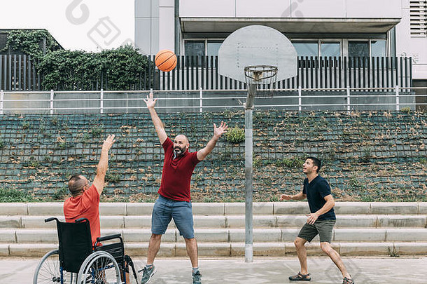快乐的禁用男人。轮椅扔球篮子朋友概念自适应体育物理活动康复peopl
