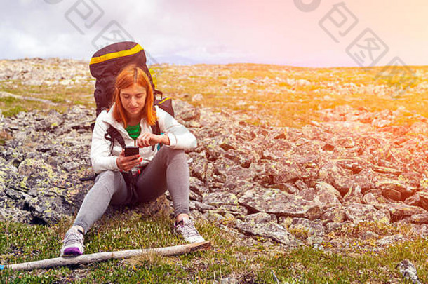 旅行生活方式生存概念后视图徒步旅行女人背包坐在岩石验证路线导航器山