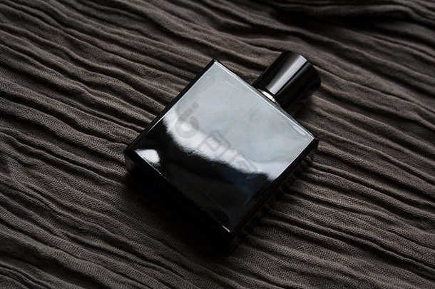 黑暗蓝色的玻璃香水瓶孤立的变形黑兹尔织物