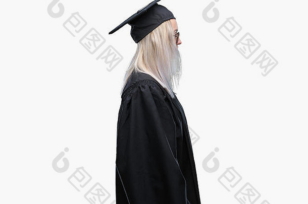 年轻的金发女郎，穿着毕业制服，在孤立的背景下，面带自信的微笑，面容自然，面容放松。