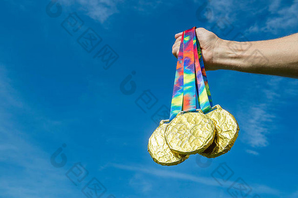 里约热内卢，手持金牌的运动员之手在蓝天下闪耀