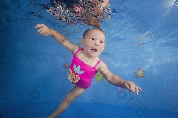 女孩粉红色的泳衣学习潜水水下池