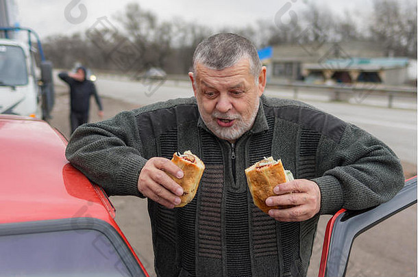 肖像高加索人饿了高级司机准备好了吃街食物车